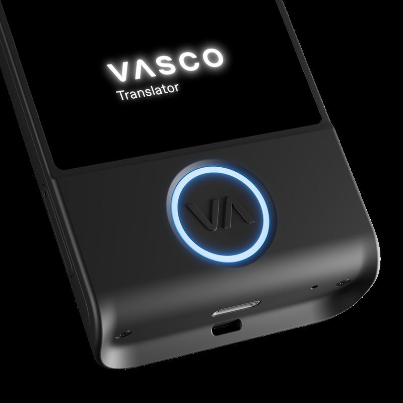 Una mano sostiene el Vasco Translator M4 en la calle; la pantalla muestra una pregunta de viaje en inglés.